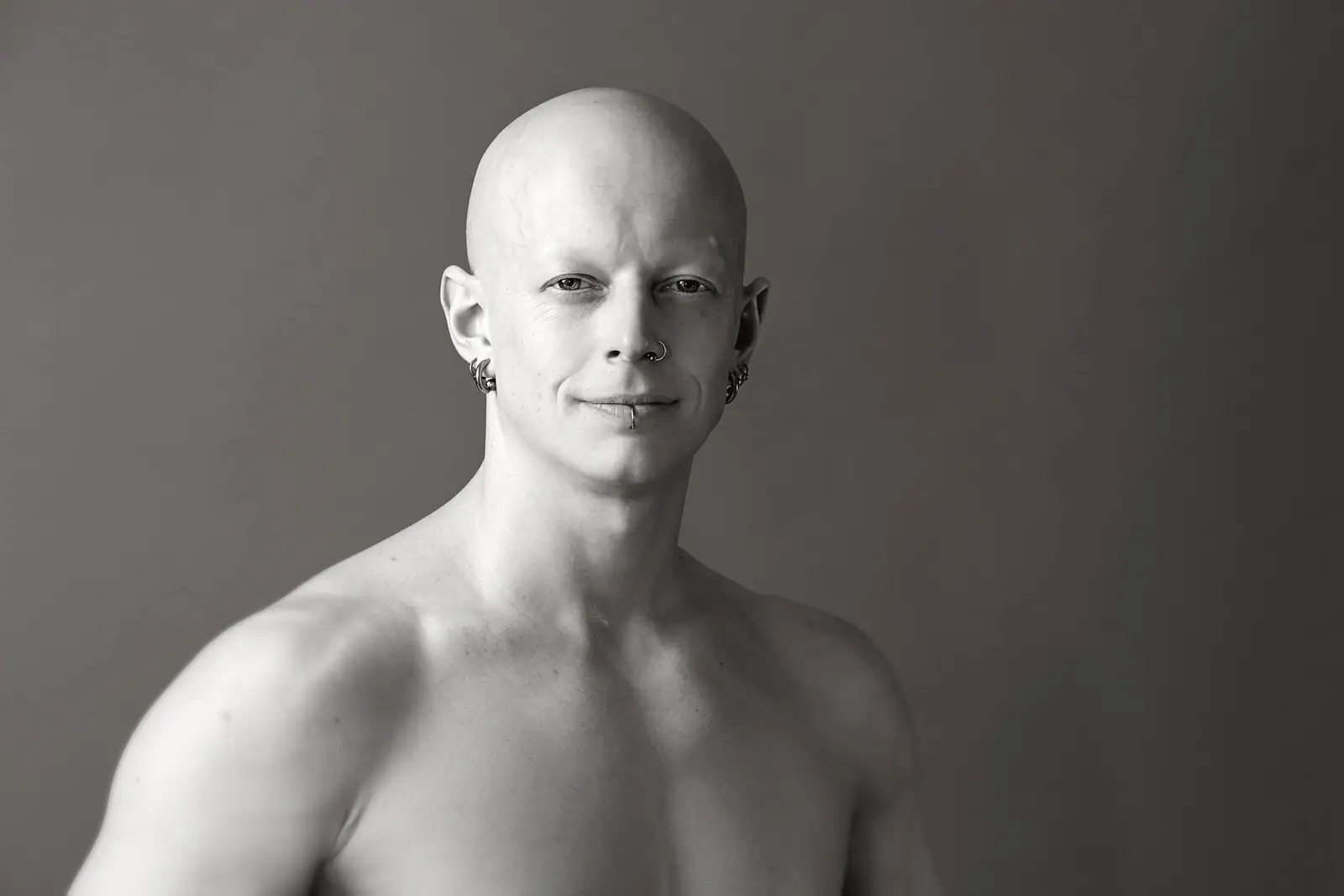Black-and-white studio portrait of Ben Lowrey smiling softly at the camera