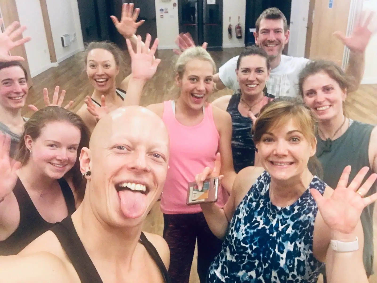 Ben Lowrey poking his tongue out in a group selfie with waving, laughing attendees